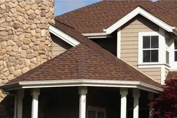 Dimensional shingle roof with intersecting rooflines above a covered porch