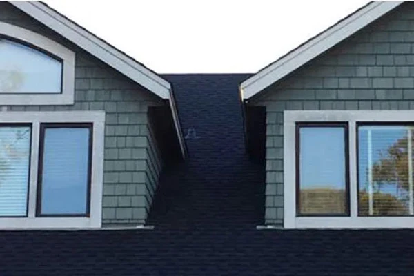 Gray shingle roof above two prominent dormer windows