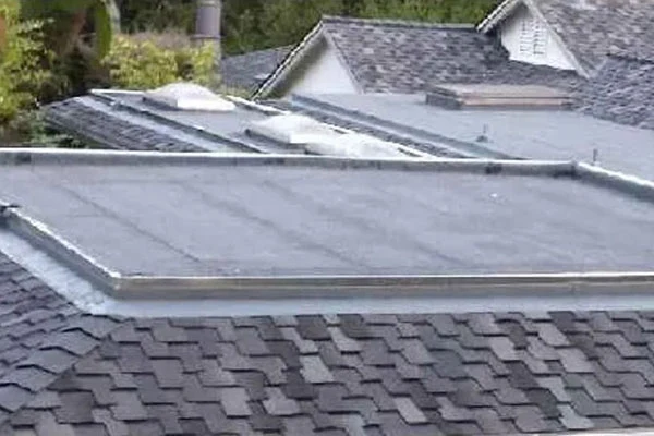 Roof with multiple glazed panels set into a shingled slope